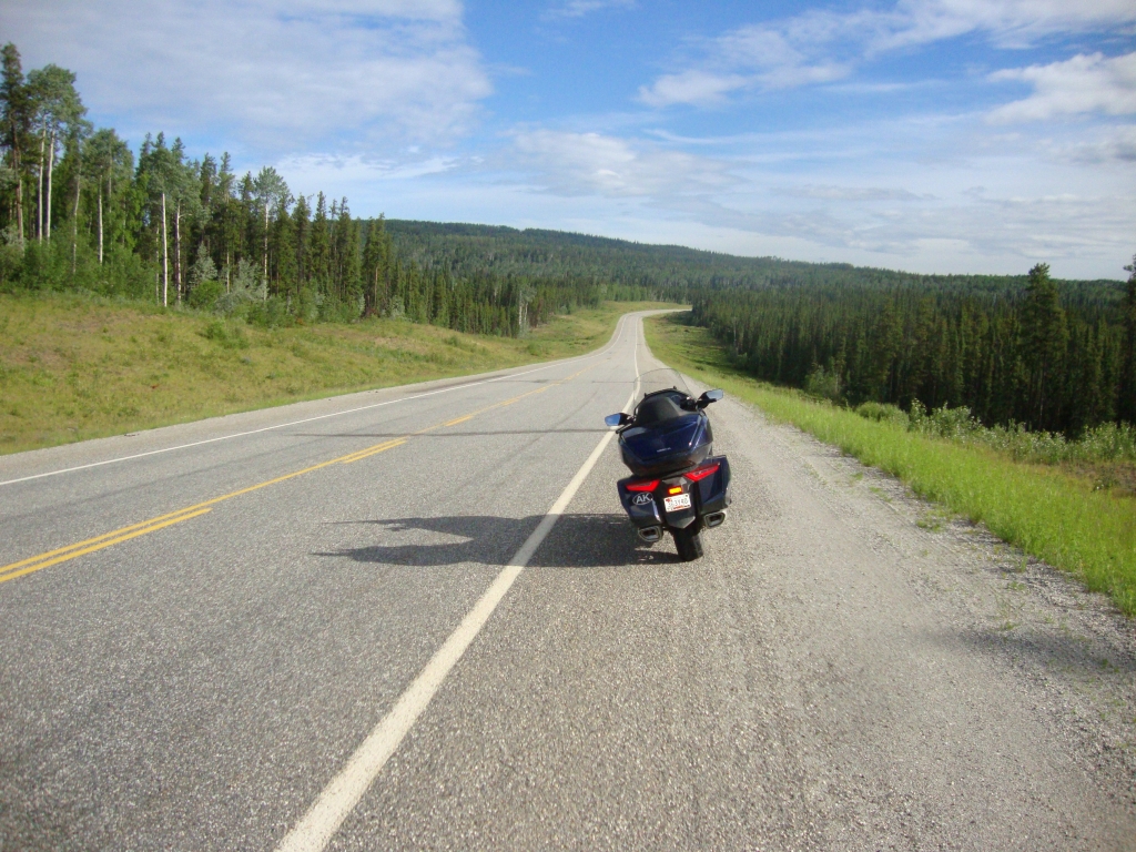 Day 4: We were about 10 miles east of Watson Lake YT at 8:30 AM when I shot this to give an idea of the road. Occasional rain soon began, and I passed a crashed 18-wheeler north of Liard Hot Springs. Two bears and two bison, one with a cute tan calf, made appearances.