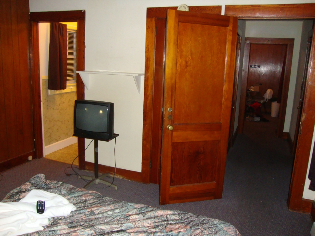 This looks from the bedroom through the entrance hall toward the dining/kitchen room; the bathroom is at the left.