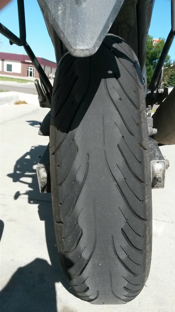 I had become concerned about the lack of tread at the center of the Michelin PR4, with 9,457 miles on it. Hearing of possible rain in Chicago I ranked peace of mind over penury and, arriving about 3 PM in Fargo, sought a new tire there.