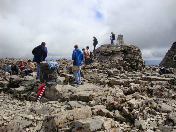 Here are some of them! My sweat-soaked blue T-shirt is drying on the round marker, which may once have had a brass disk showing bearings to other peaks. I was later to see a similar round column on Ben MacDui.  